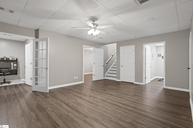 interior space with a paneled ceiling, ceiling fan, and dark wood-type flooring