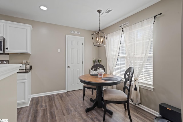 dining space featuring dark hardwood / wood-style floors and a notable chandelier