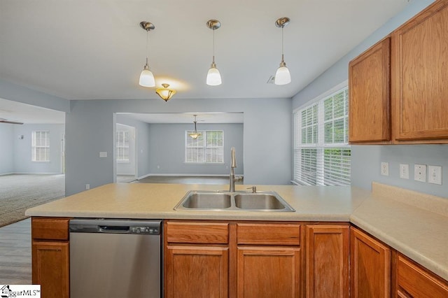 kitchen with carpet flooring, dishwasher, sink, kitchen peninsula, and decorative light fixtures