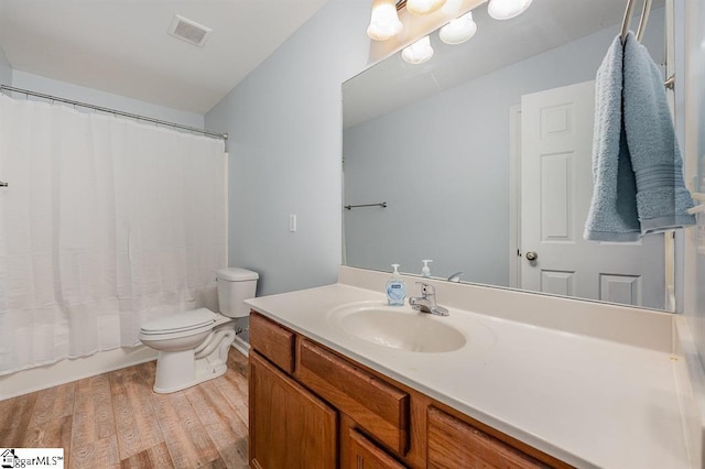 full bathroom featuring hardwood / wood-style floors, vanity, shower / bath combination with curtain, and toilet