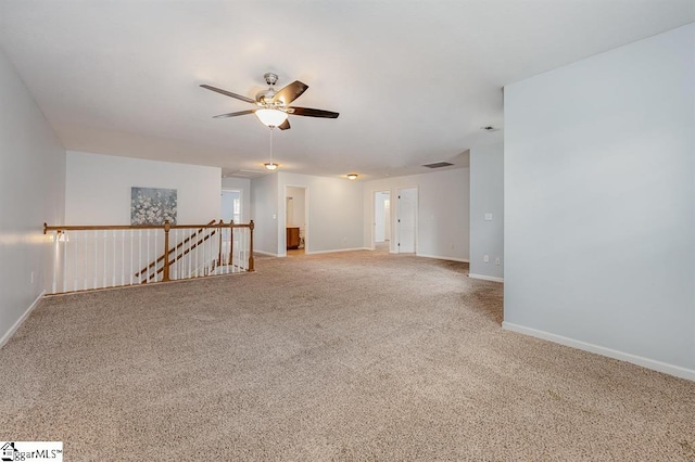 spare room featuring ceiling fan and light carpet