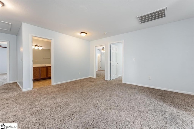 unfurnished bedroom with connected bathroom and light colored carpet