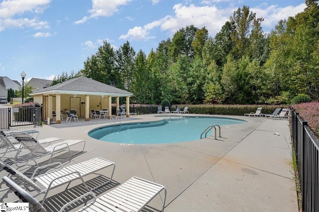 view of swimming pool featuring ceiling fan and a patio area