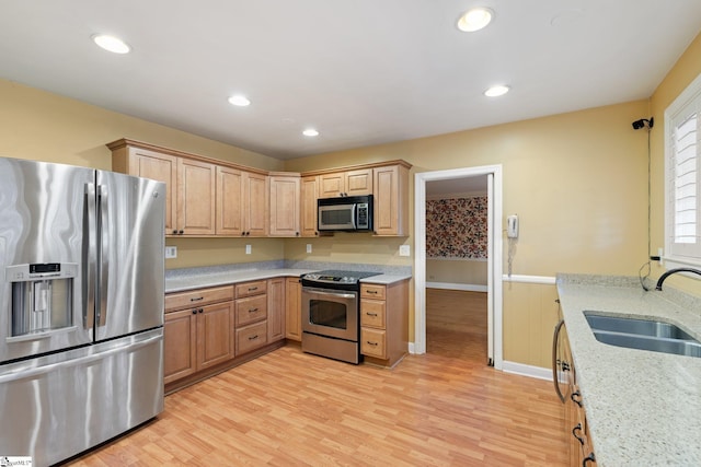 kitchen featuring sink, light wood-type flooring, light brown cabinetry, appliances with stainless steel finishes, and light stone counters