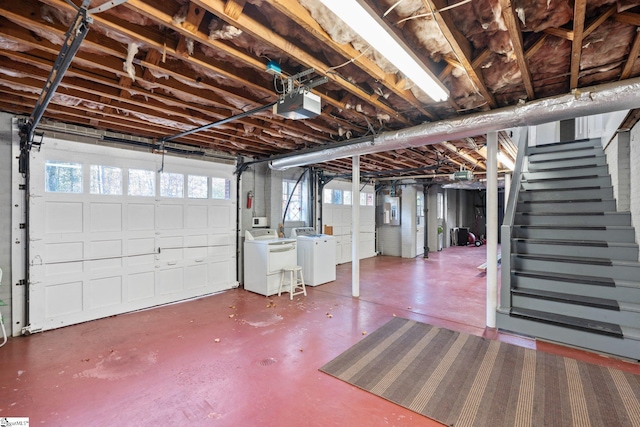 garage featuring electric panel, a garage door opener, and washer and clothes dryer