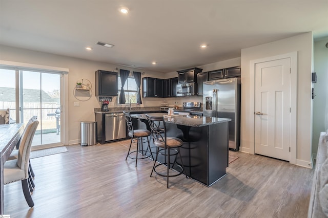 kitchen featuring a center island, stainless steel appliances, plenty of natural light, and light hardwood / wood-style flooring