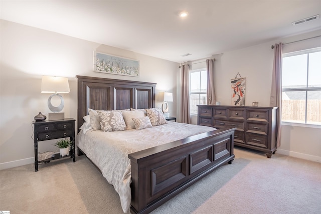 bedroom with light carpet and multiple windows