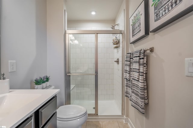 bathroom with tile patterned flooring, vanity, toilet, and walk in shower