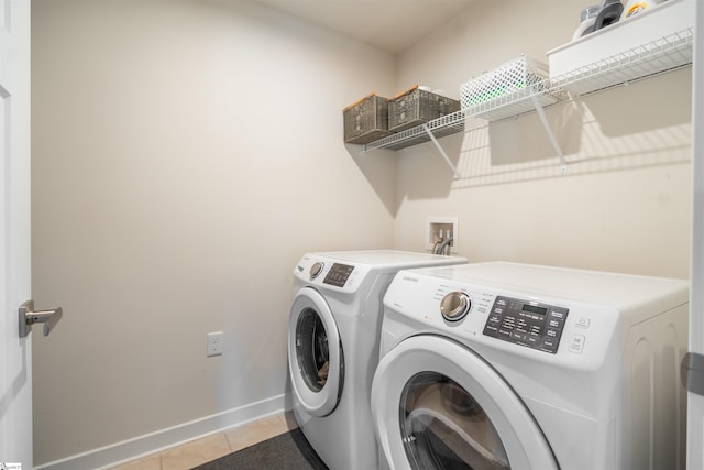 laundry area featuring separate washer and dryer and light tile patterned floors