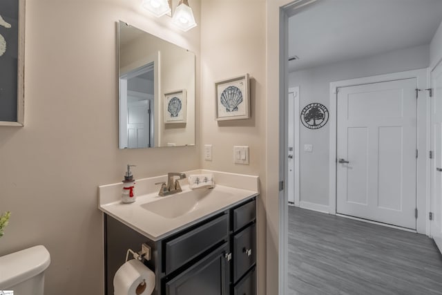 bathroom featuring vanity, hardwood / wood-style flooring, and toilet