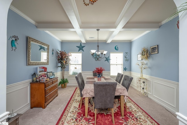 carpeted dining area featuring beam ceiling, coffered ceiling, a notable chandelier, and ornamental molding