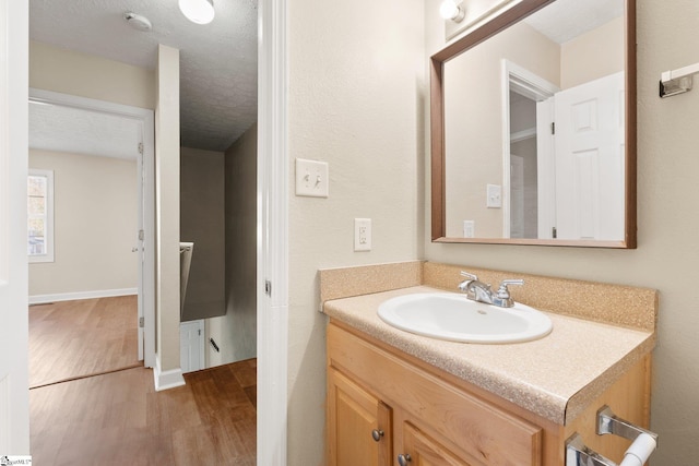 bathroom with vanity, a textured ceiling, and hardwood / wood-style flooring