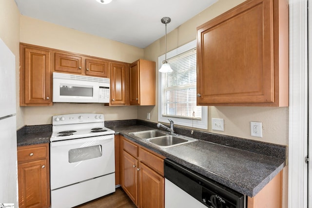 kitchen with sink, hanging light fixtures, and white appliances