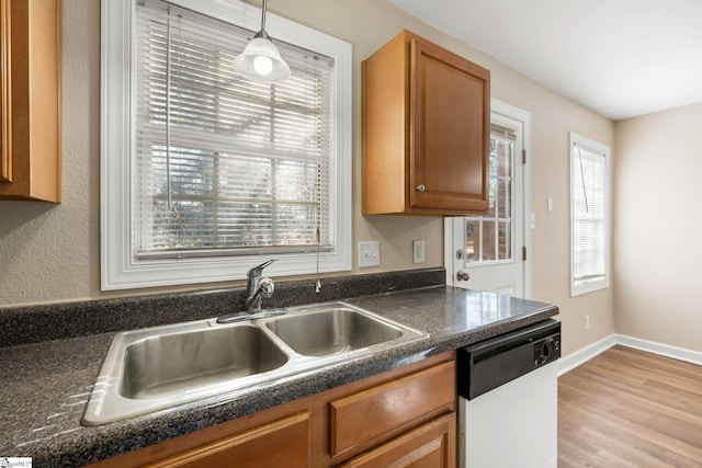 kitchen with dishwasher, light hardwood / wood-style floors, hanging light fixtures, and sink