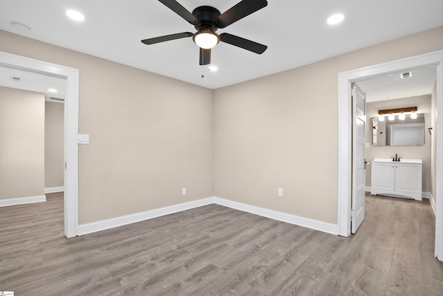 unfurnished bedroom with ceiling fan, light hardwood / wood-style floors, and ensuite bath