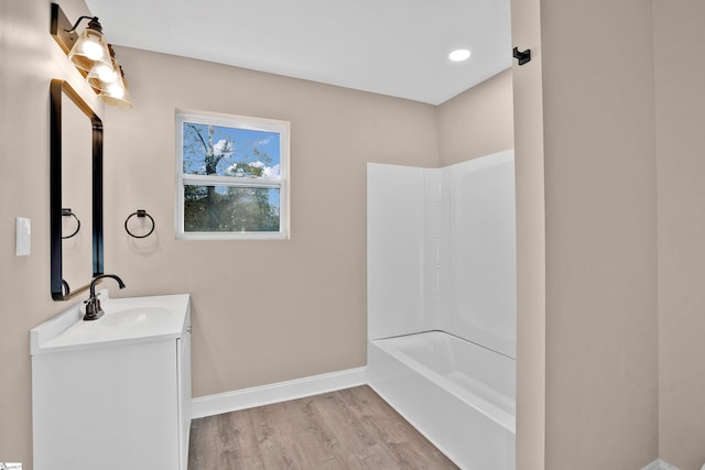 bathroom with shower / bathing tub combination, wood-type flooring, and vanity