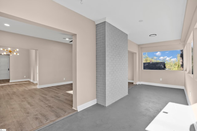 unfurnished living room featuring concrete flooring and a notable chandelier