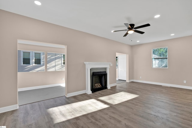 unfurnished living room featuring ceiling fan and hardwood / wood-style flooring