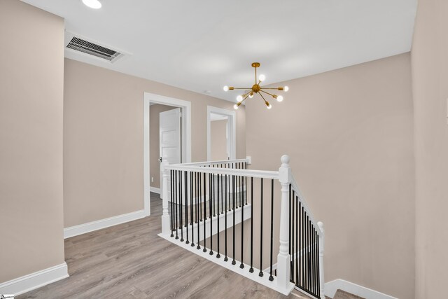 hall featuring light hardwood / wood-style flooring and a notable chandelier