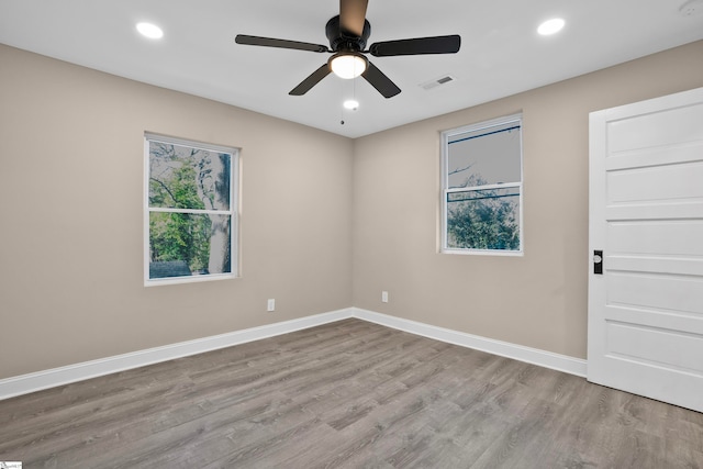 spare room with ceiling fan and light wood-type flooring