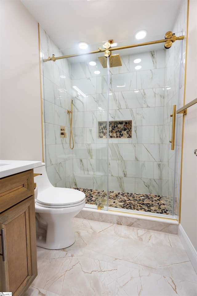 bathroom featuring ceiling fan, a shower with door, vanity, and toilet