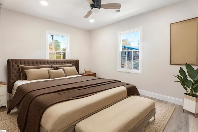 bedroom featuring light hardwood / wood-style floors, multiple windows, and ceiling fan