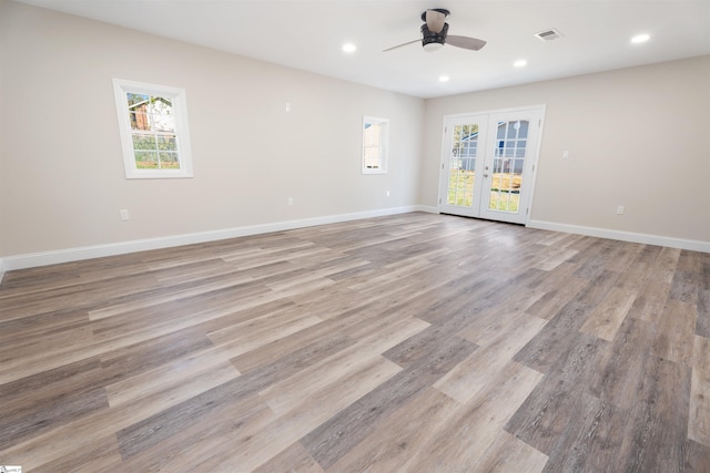 empty room with ceiling fan, french doors, and light hardwood / wood-style flooring