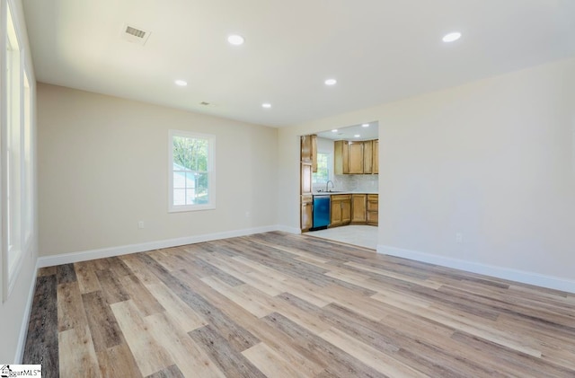 unfurnished living room with sink and light wood-type flooring