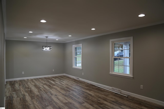 empty room with dark hardwood / wood-style floors, ornamental molding, and a wealth of natural light