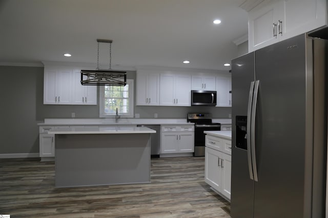 kitchen with white cabinets, crown molding, hardwood / wood-style flooring, appliances with stainless steel finishes, and decorative light fixtures