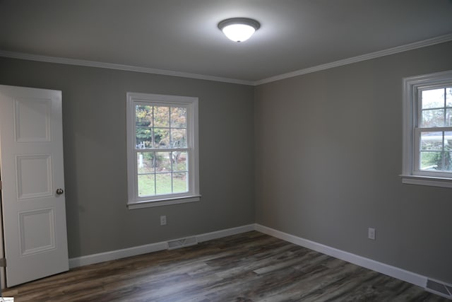 empty room with plenty of natural light, crown molding, and dark wood-type flooring