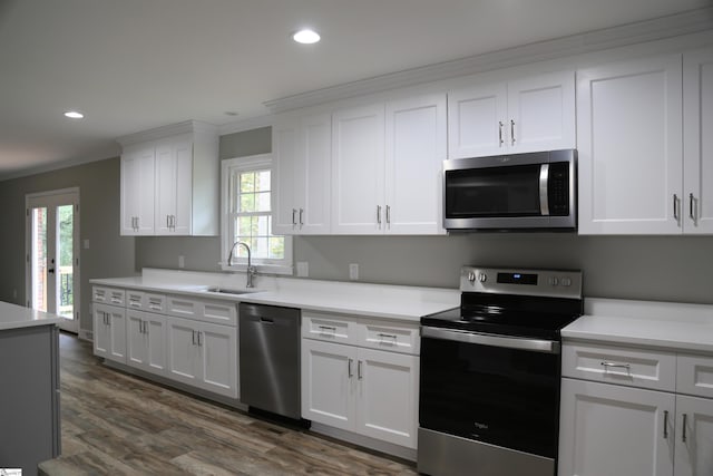 kitchen with appliances with stainless steel finishes, white cabinetry, plenty of natural light, and sink