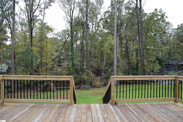 wooden deck featuring a lawn