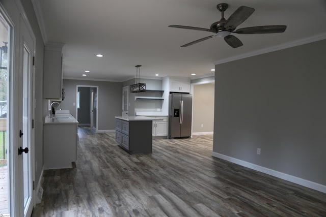 kitchen featuring stainless steel fridge with ice dispenser, white cabinetry, ornamental molding, and dark wood-type flooring