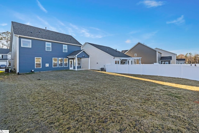 rear view of property featuring a yard and central AC unit