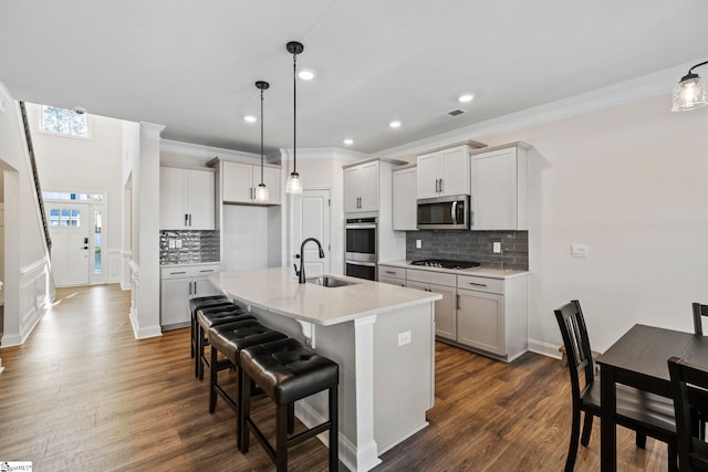 kitchen featuring dark hardwood / wood-style flooring, a kitchen island with sink, sink, and stainless steel appliances