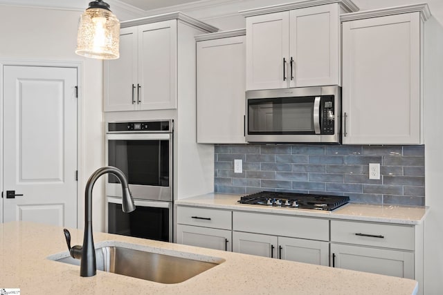 kitchen featuring light stone countertops, sink, stainless steel appliances, and ornamental molding