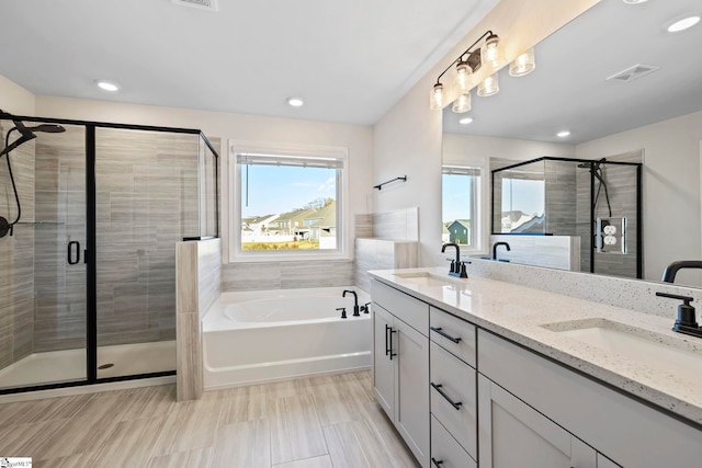 bathroom featuring vanity and shower with separate bathtub