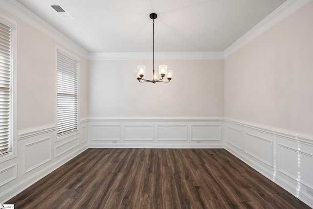 unfurnished room featuring dark hardwood / wood-style floors, crown molding, and a chandelier