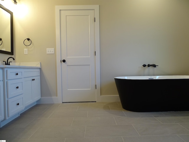 bathroom with tile patterned floors, vanity, and a tub