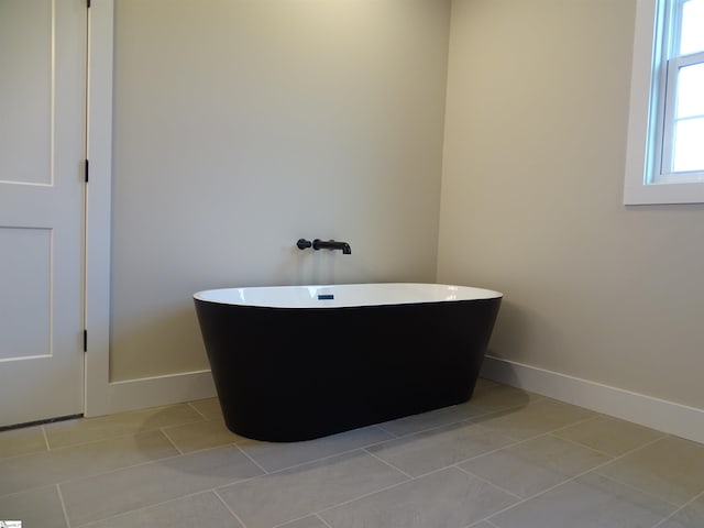 bathroom featuring a tub to relax in and tile patterned flooring