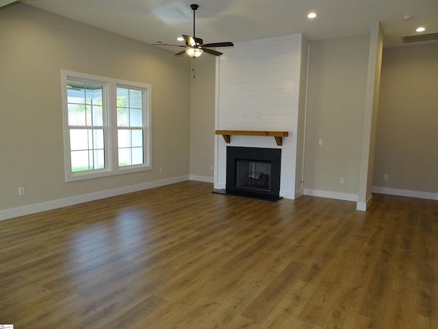 unfurnished living room featuring ceiling fan, a fireplace, and wood-type flooring