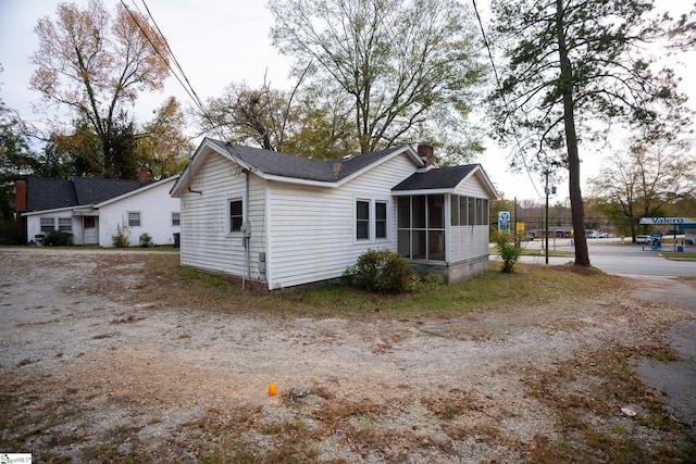 view of property exterior with a sunroom