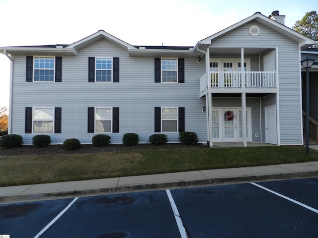 view of front of property featuring a balcony and a front lawn