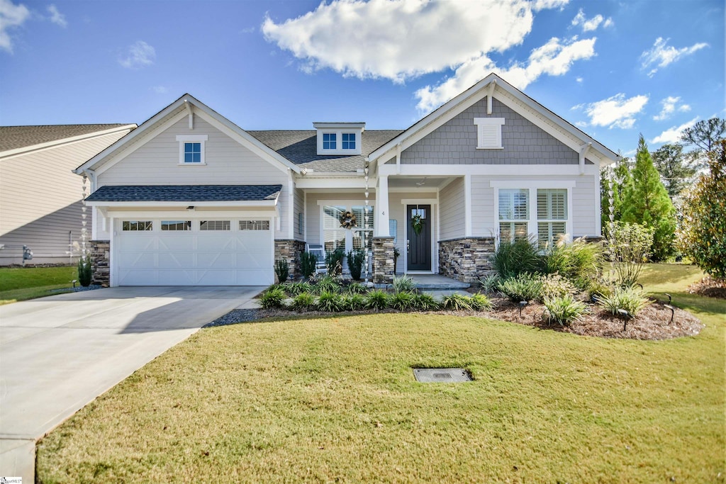 craftsman house with a front yard and a garage