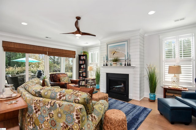 living room featuring crown molding, plenty of natural light, ceiling fan, and light hardwood / wood-style floors