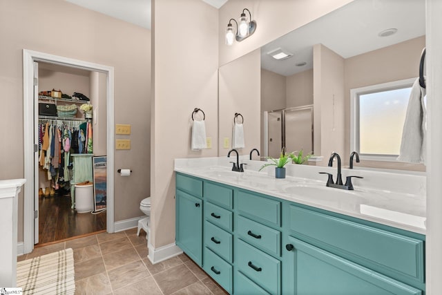 bathroom with vanity, hardwood / wood-style flooring, toilet, and a shower with door