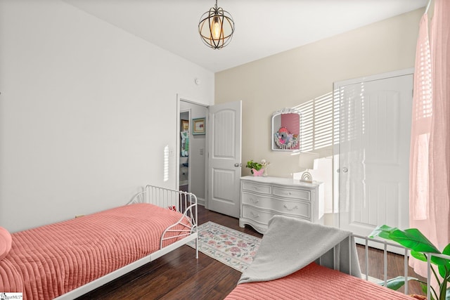 bedroom with dark hardwood / wood-style flooring and a baseboard radiator