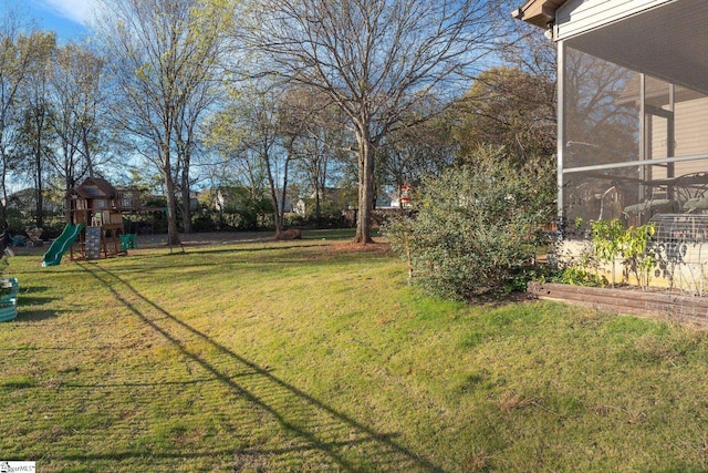 view of yard featuring a playground and a sunroom