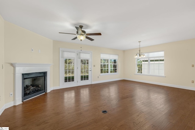 unfurnished living room with dark hardwood / wood-style flooring and ceiling fan with notable chandelier